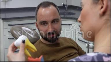 牙医正在给病人展示一种<strong>牙齿模型</strong>
